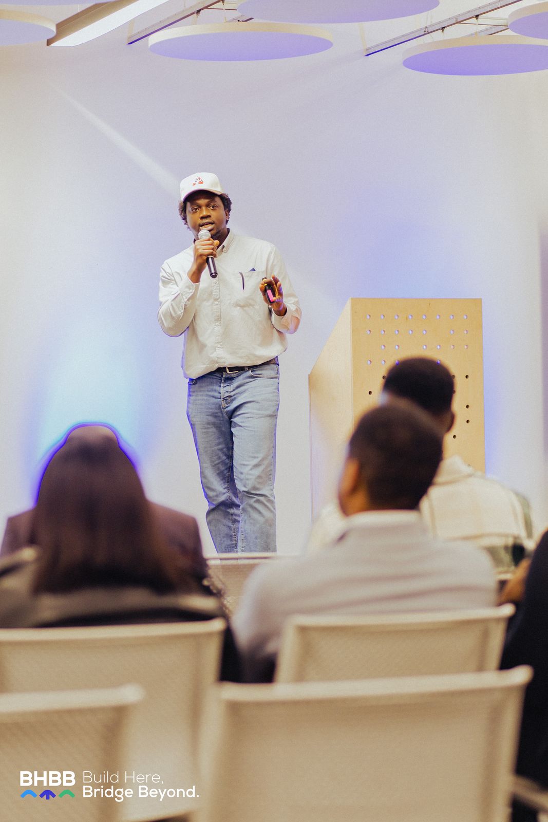 Ikechukwu speaking on stage with a microphone in front of an audience